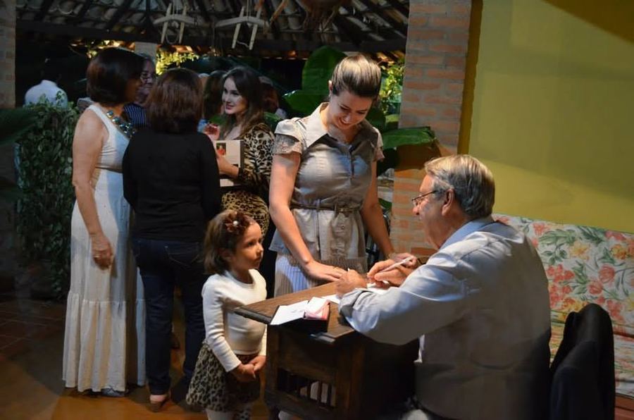 Luzia, a filhinha do Décio,muito séria esperando o autógrafo  ao lado...