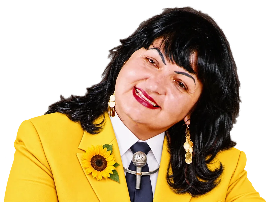 Soninha, de blazer amarelo e girassol na lapela, sorrindo